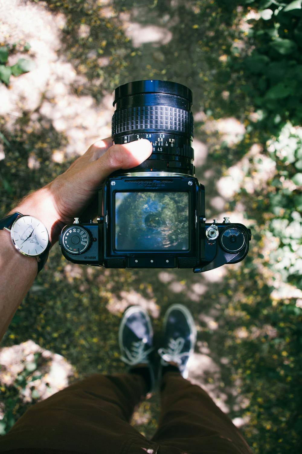 pessoa segurando câmera DSLR preta