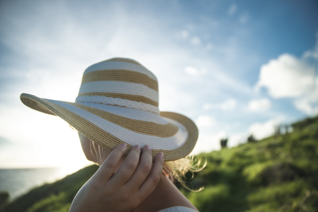 woman holding beige and gray sun hat, End of the day