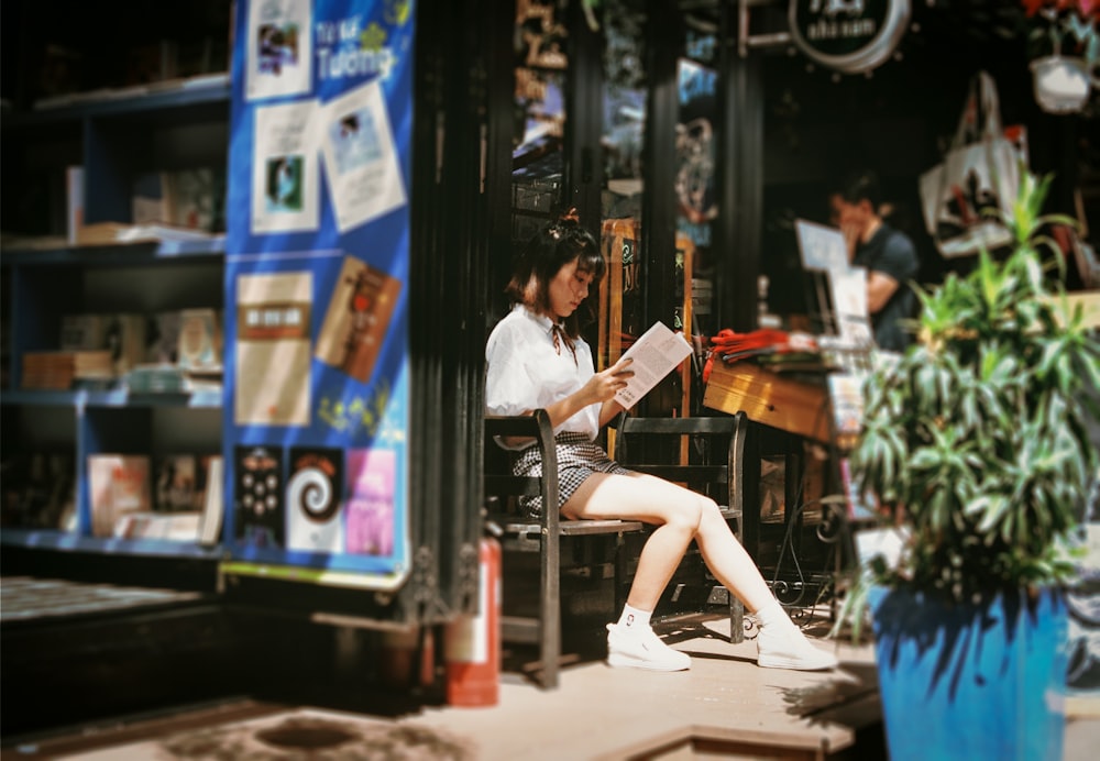 Frau, die ein Buch liest, sitzt auf der Bank