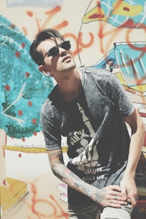 Close-up of a model wearing a bold graphic rawvolt t-shirt against an urban graffiti wall