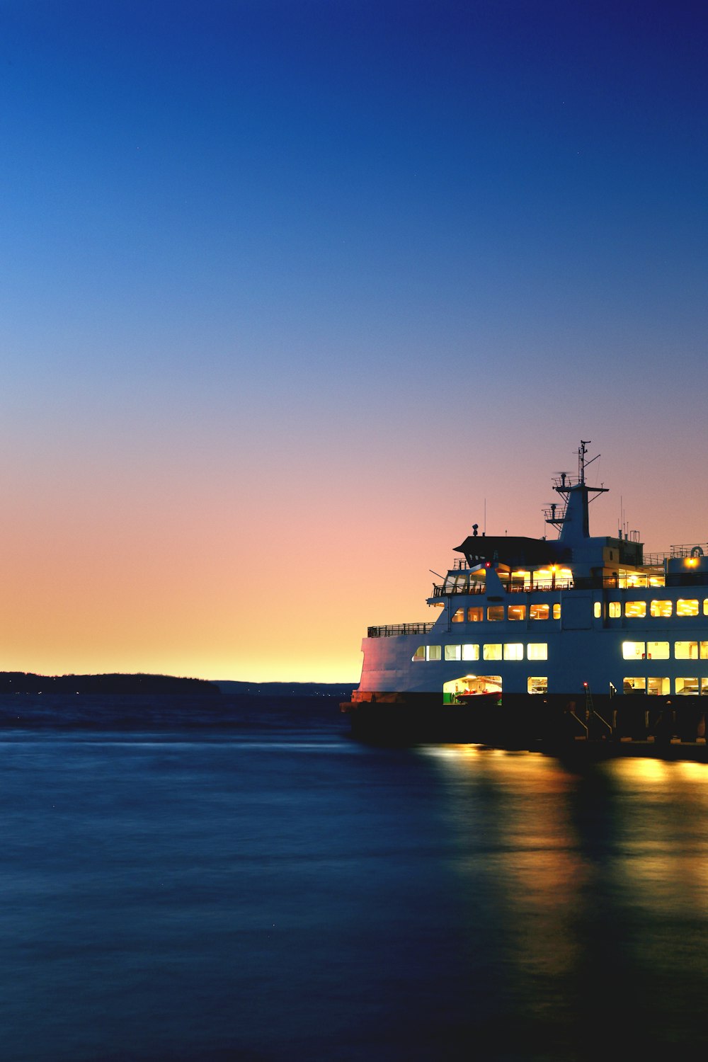 lighted cruiseship on sea taken during golden hour