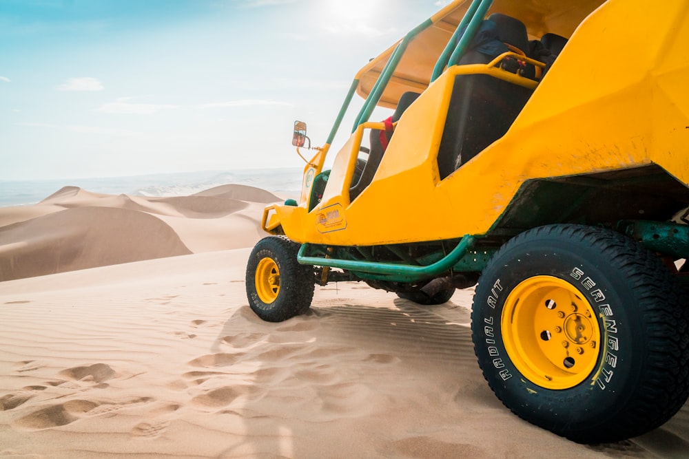 yellow and green UTV parked on a desert field