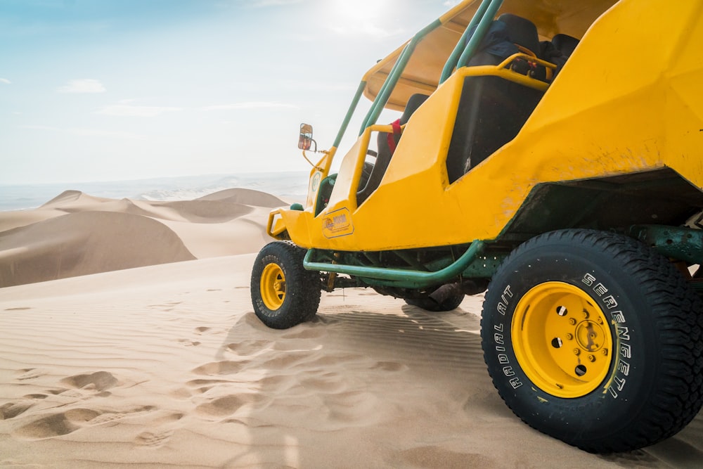 UTV jaune et vert garé sur un champ désertique