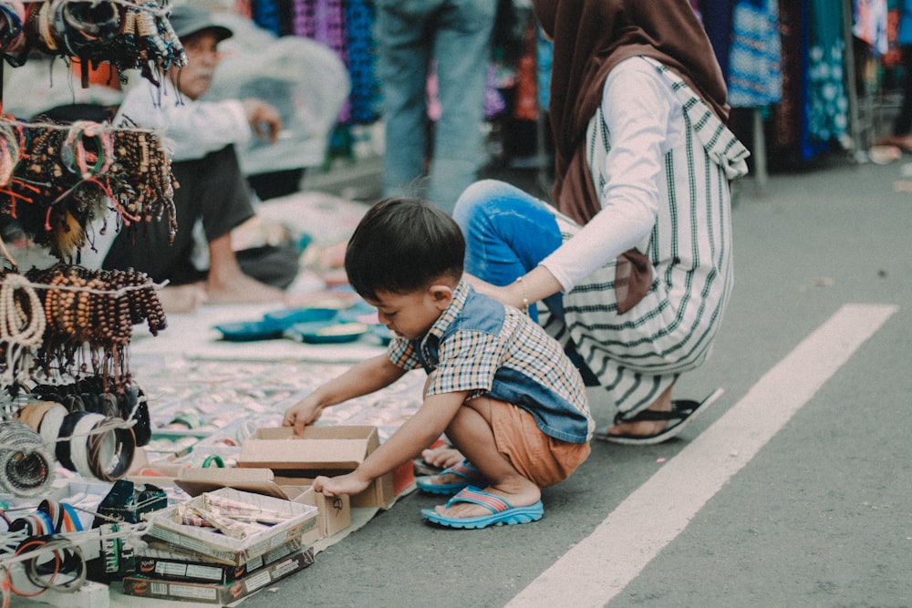 child doing asian squat on asphalt road