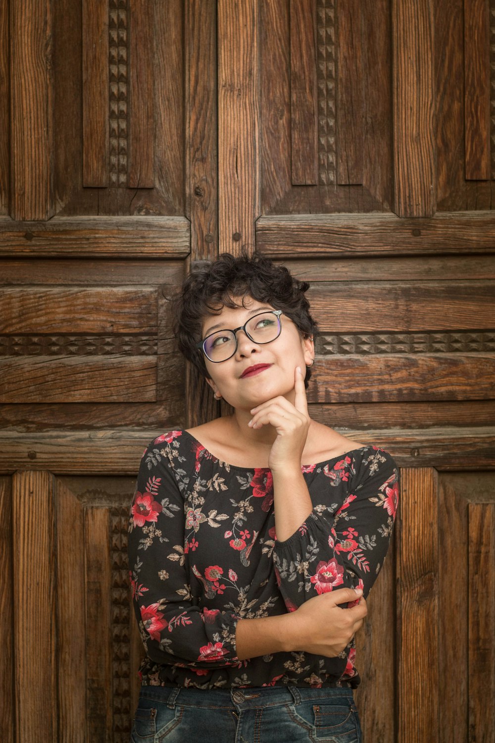 woman leaning against door while holding her cheek