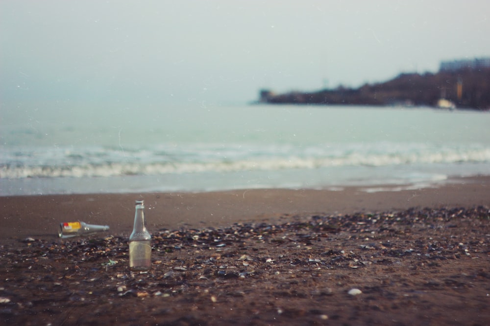 clear glass bottle on beach