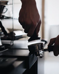 Espresso tamper pressing coffee grounds in a portafilter basket