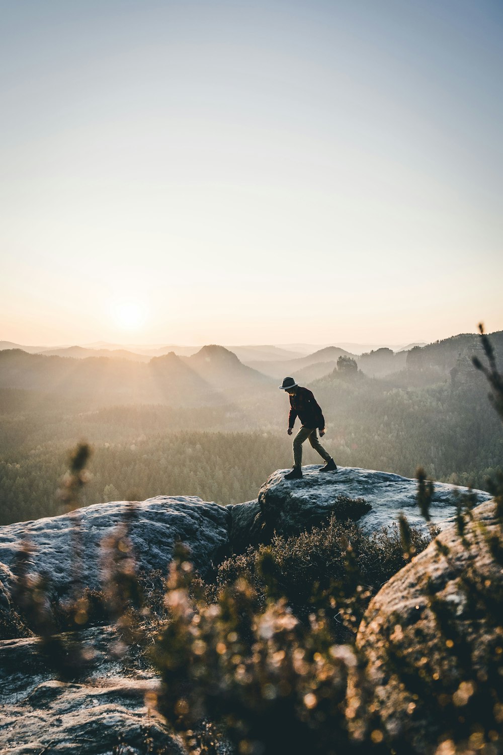 Uomo che cammina sulla montagna di roccia grigia durante il giorno