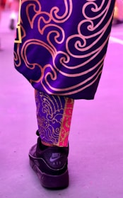 Close-up of feet moving rhythmically under shimmering purple lights.