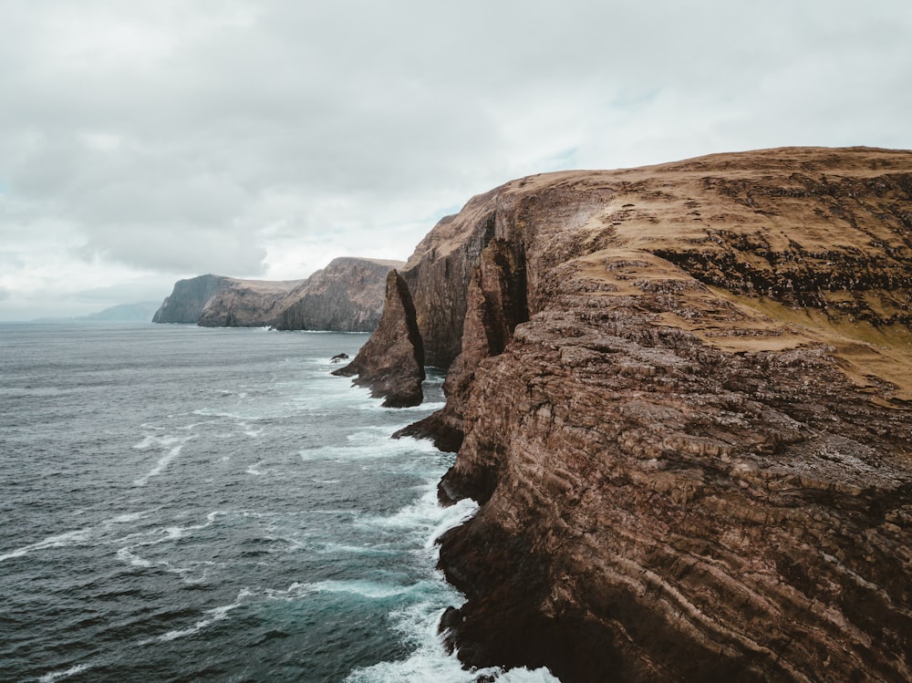 brown rock formation under grey clouds