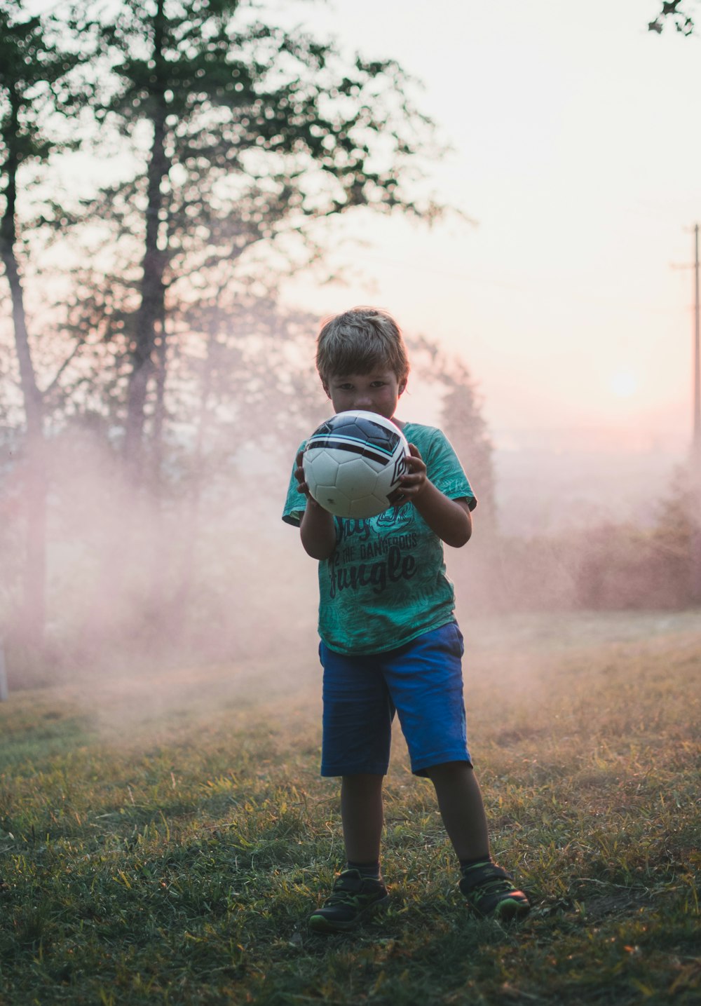 shallow focus photography of boy holding a ball