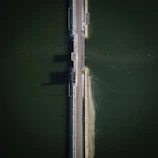 An aerial view of a newly completed concrete bridge spanning a river.