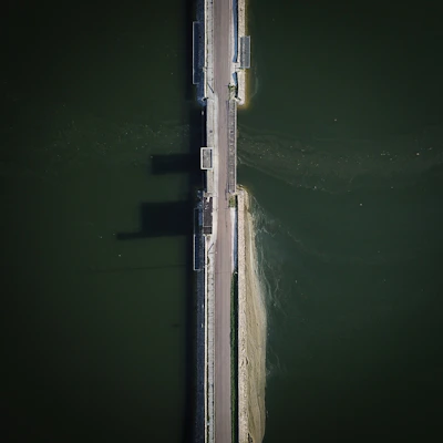 An aerial view of a newly completed concrete bridge spanning a river.