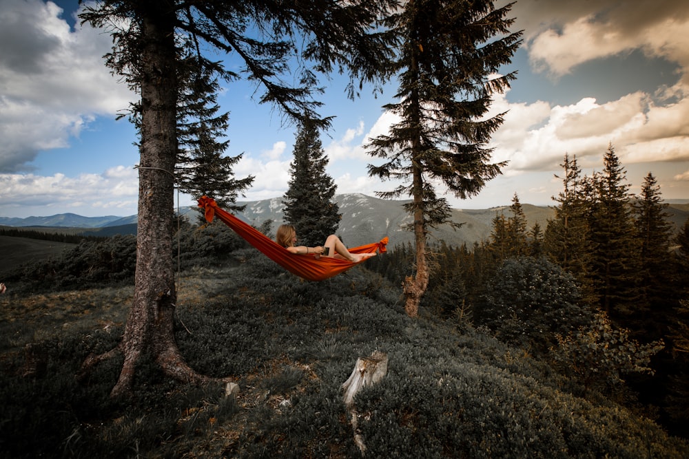 person lying on red hammock