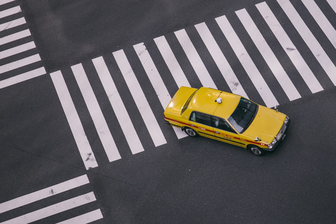 yellow taxi on gray pave road during daytime