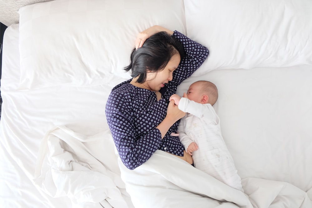 woman and baby lying on bed