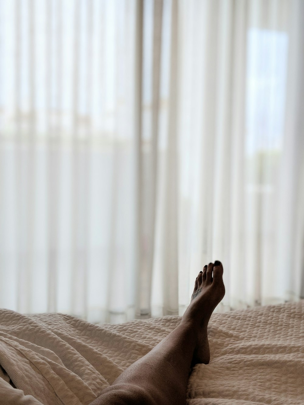 person lying on brown bed sheet