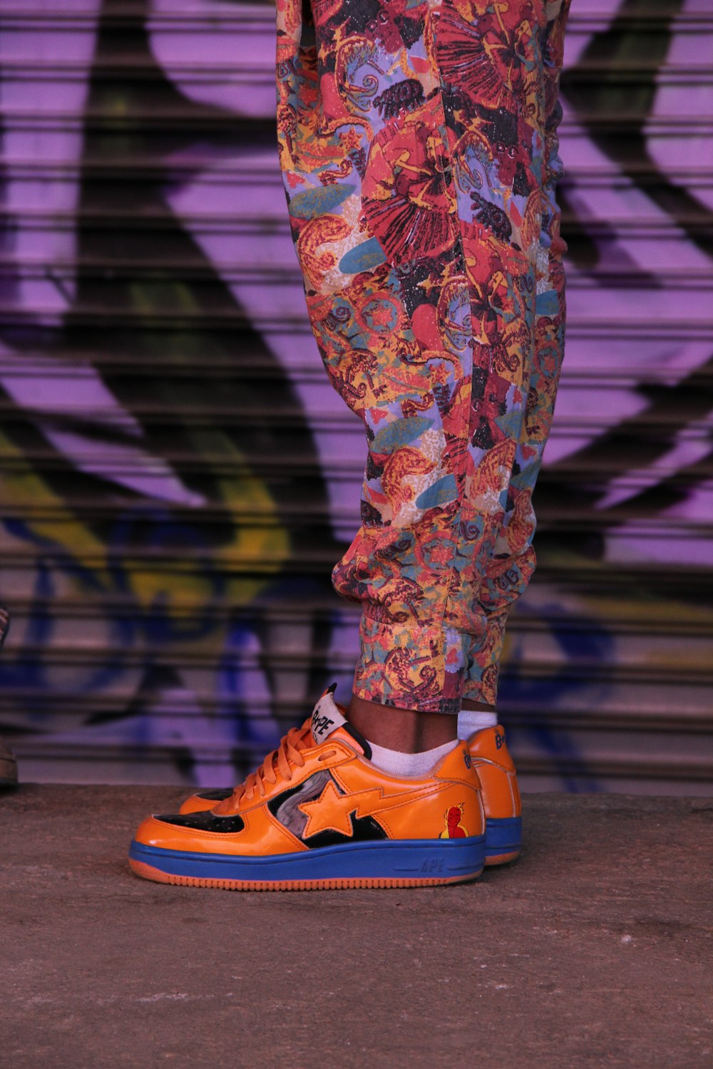 person wearing orange-and-blue low-top sneakers