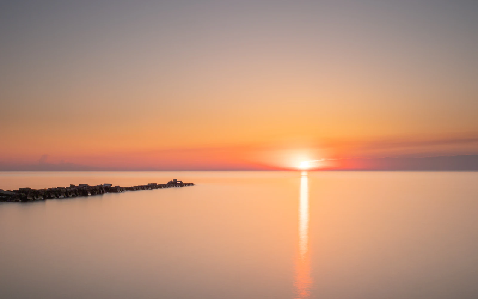Quiet power of stillness shown through bright golden water at sunrise