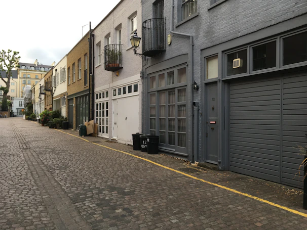 Quiet street view of a beige and green toned residential area with classic architecture.