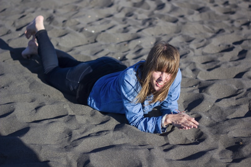 Mujer recostada en la arena gris volcánica de Pichilemu
