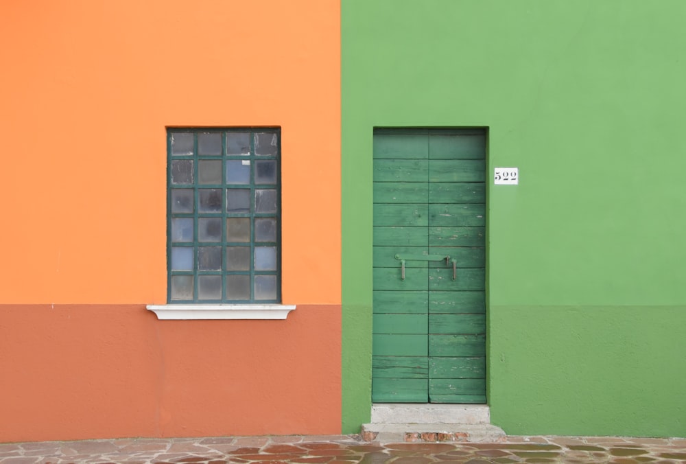 Ein grün-orangefarbenes Gebäude mit einem Fenster