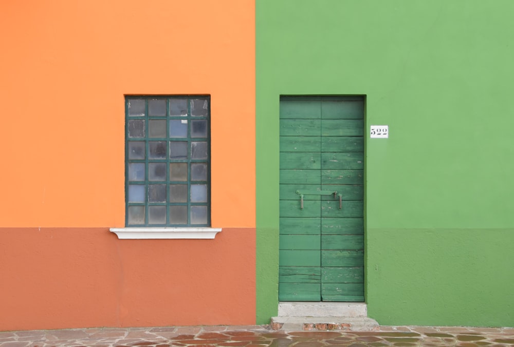 Un edificio verde y naranja con ventana