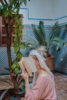 woman sitting on chair while reading book in a moroccan riad