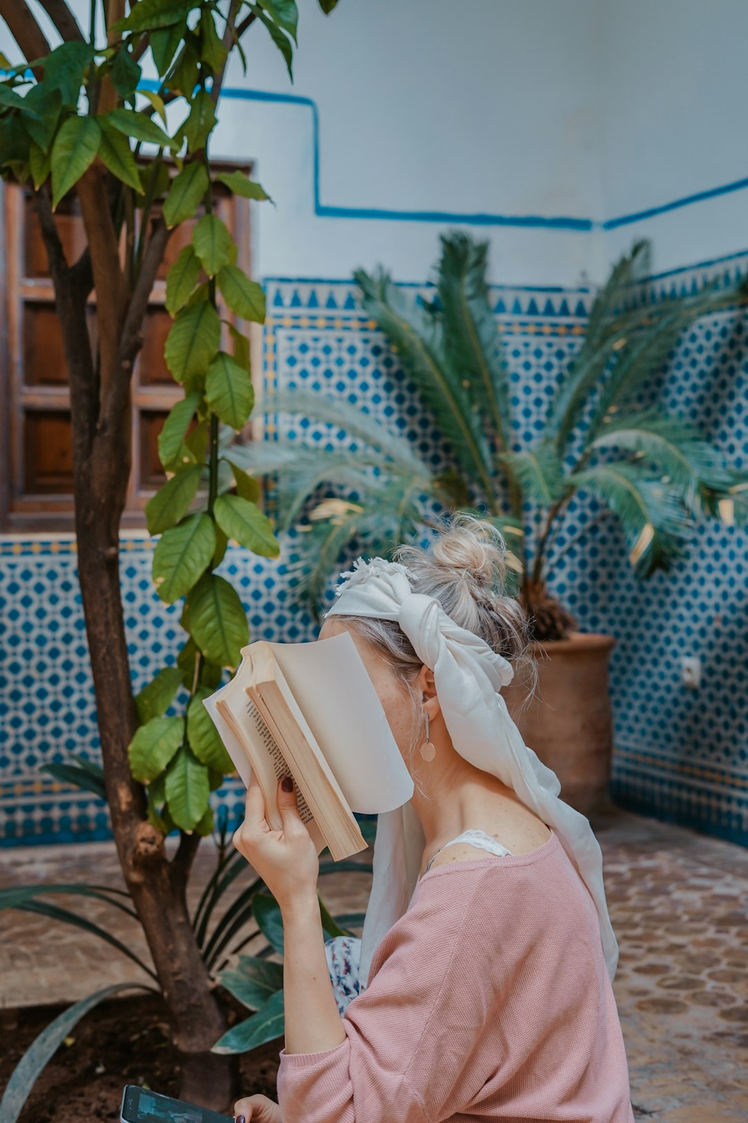 woman sitting on chair while reading book