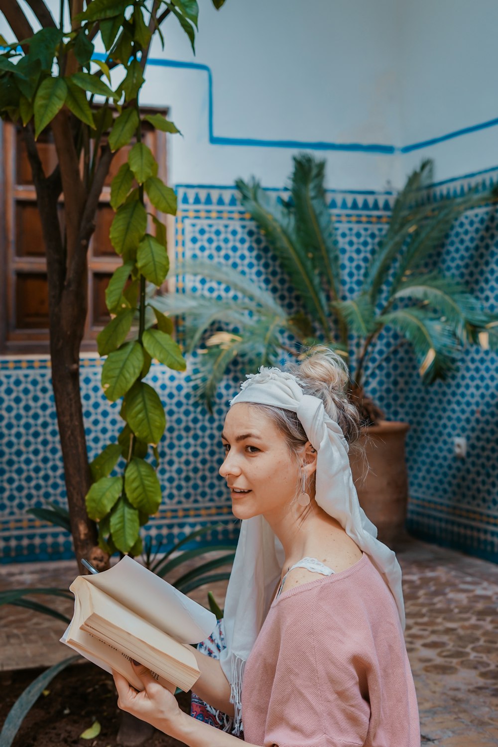 woman reading a book near tree