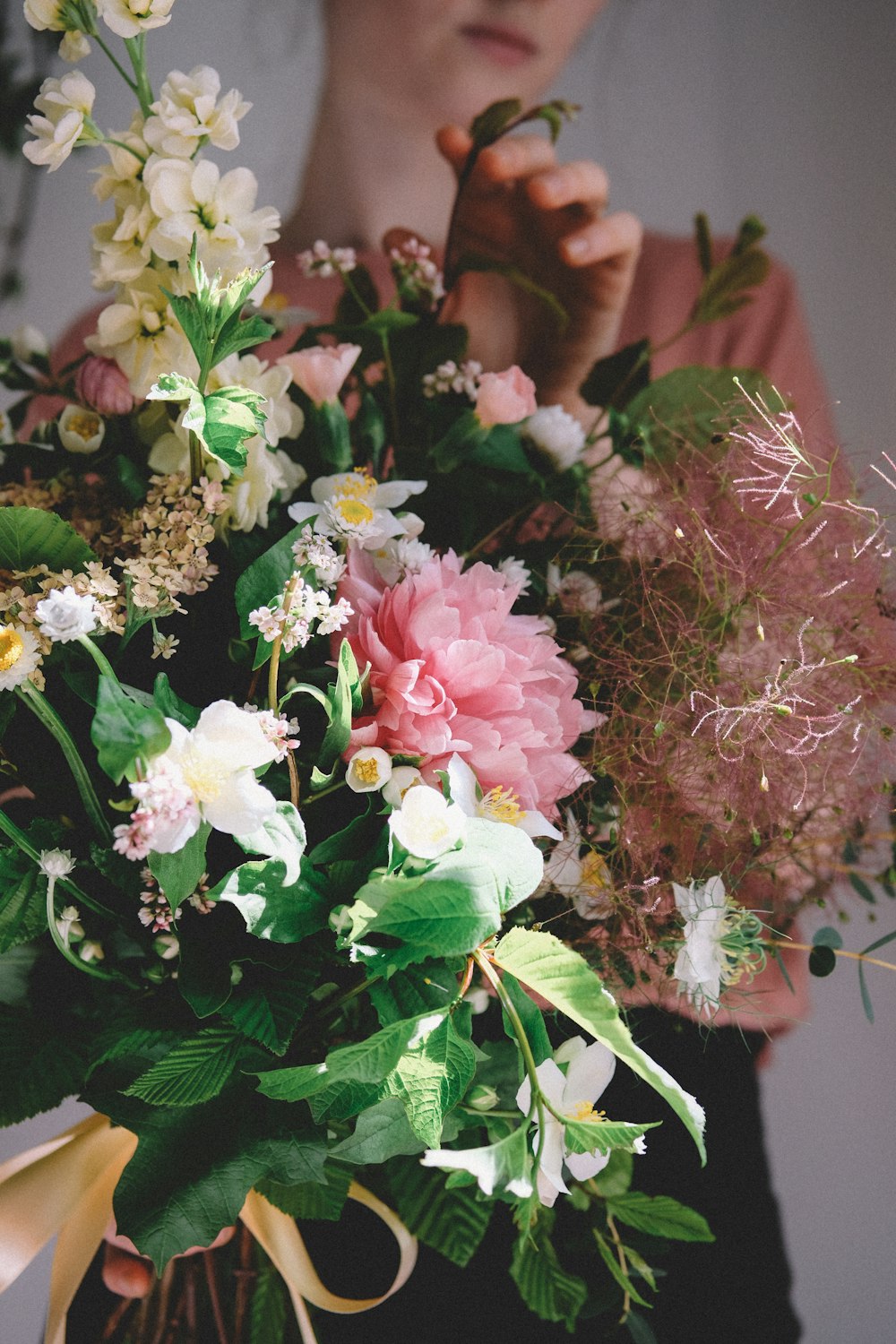 Femme tenant une plante à feuilles vertes