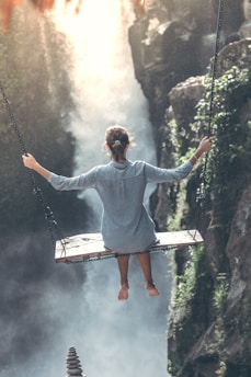 woman riding on wooden swing