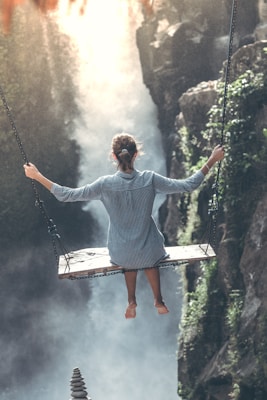 woman riding on wooden swing
