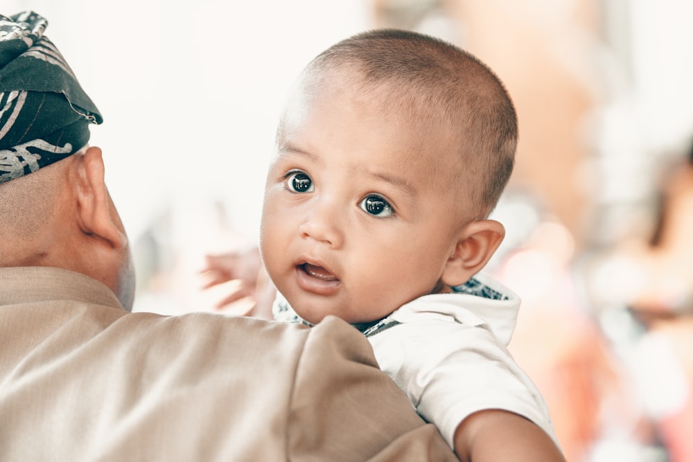 baby carried by man