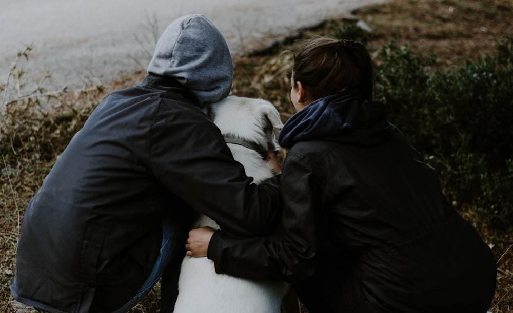 man and woman holding Labrador retriever