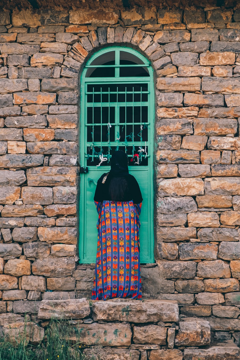 Mujer de pie frente a la puerta verde