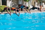 four men diving to the pool