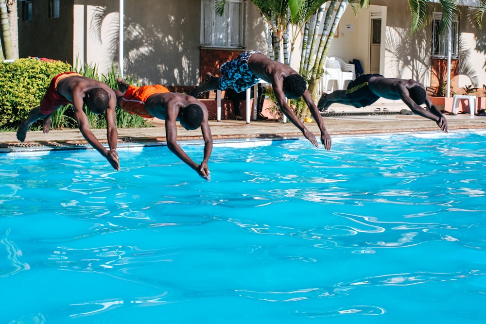 four men diving to the pool