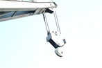 Close-up of a powerful crane hook holding a heavy load with a clear blue sky background.