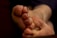 Close-up of a person's foot with short, damaged toenails. The toenails have remnants of dark nail polish, and some appear to have injuries or imperfections. The background is blurred, focusing attention on the foot.