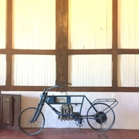 A classic vintage motorcycle displayed against a rustic wooden wall