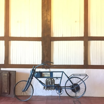 A classic vintage motorcycle displayed against a rustic wooden wall
