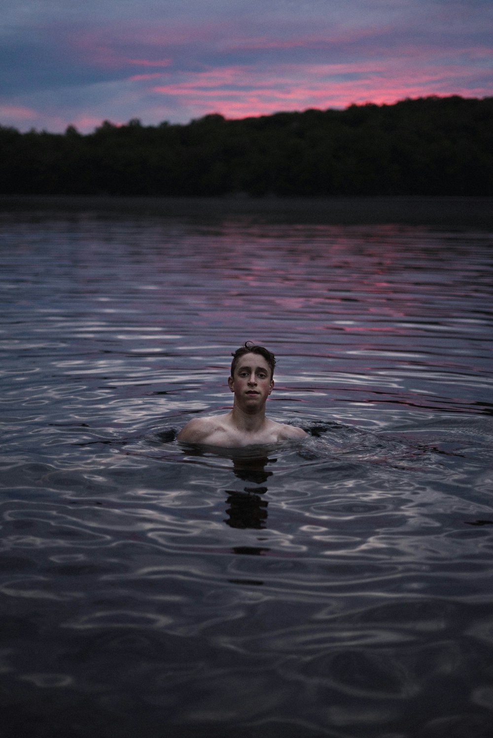 man swimming on body of water