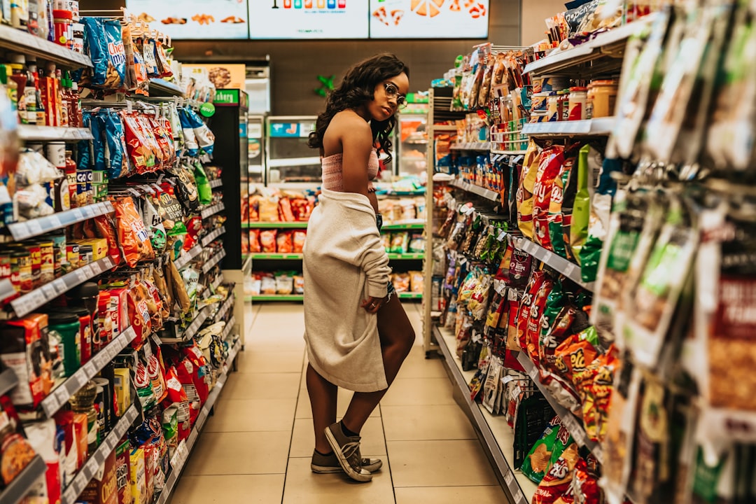woman posing between store shelves with products in store interior