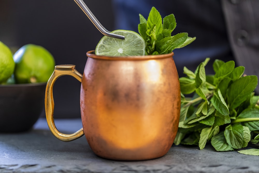 brass-colored mug with sliced lime