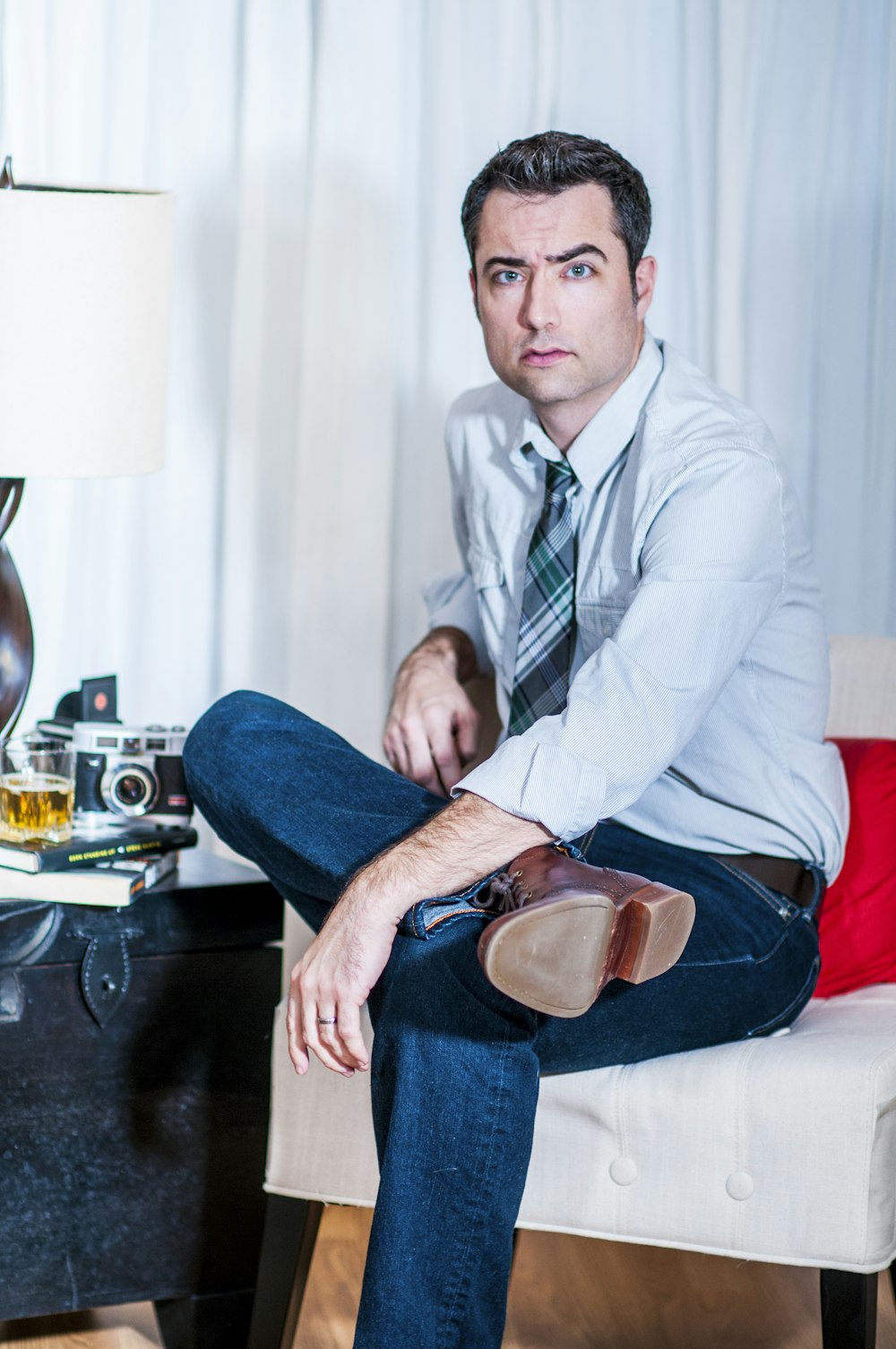 man cross-legged sitting on padded sofa chair