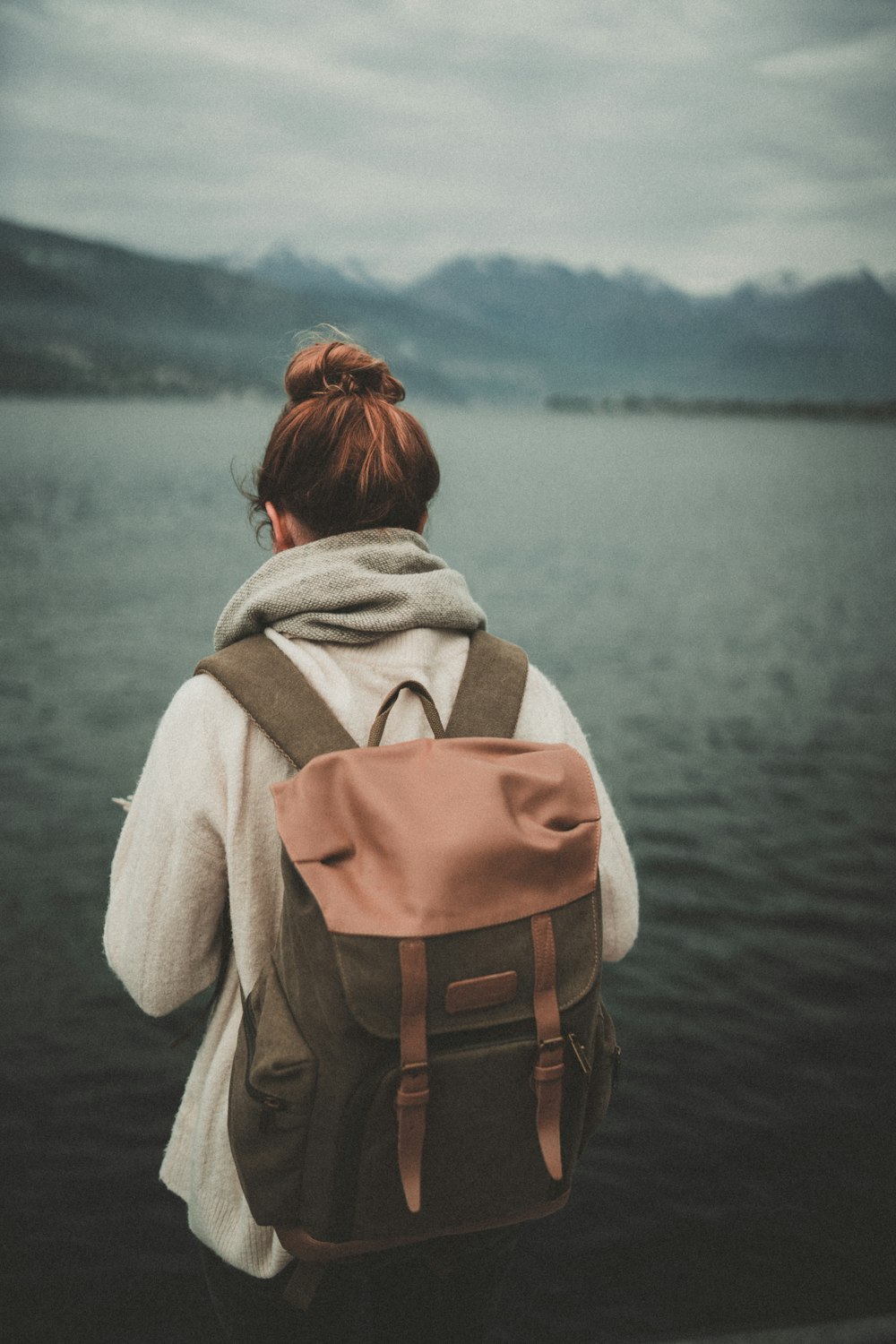 woman standing nearby calm body of water ]