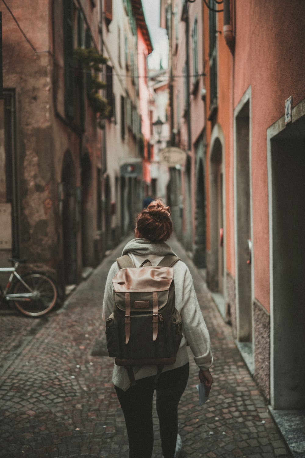 Mujer caminando por la calle rodeada de edificios