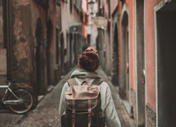 woman walking on street surrounded by buildings