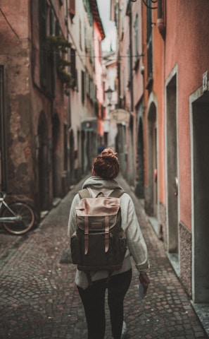 woman walking on street surrounded by buildings